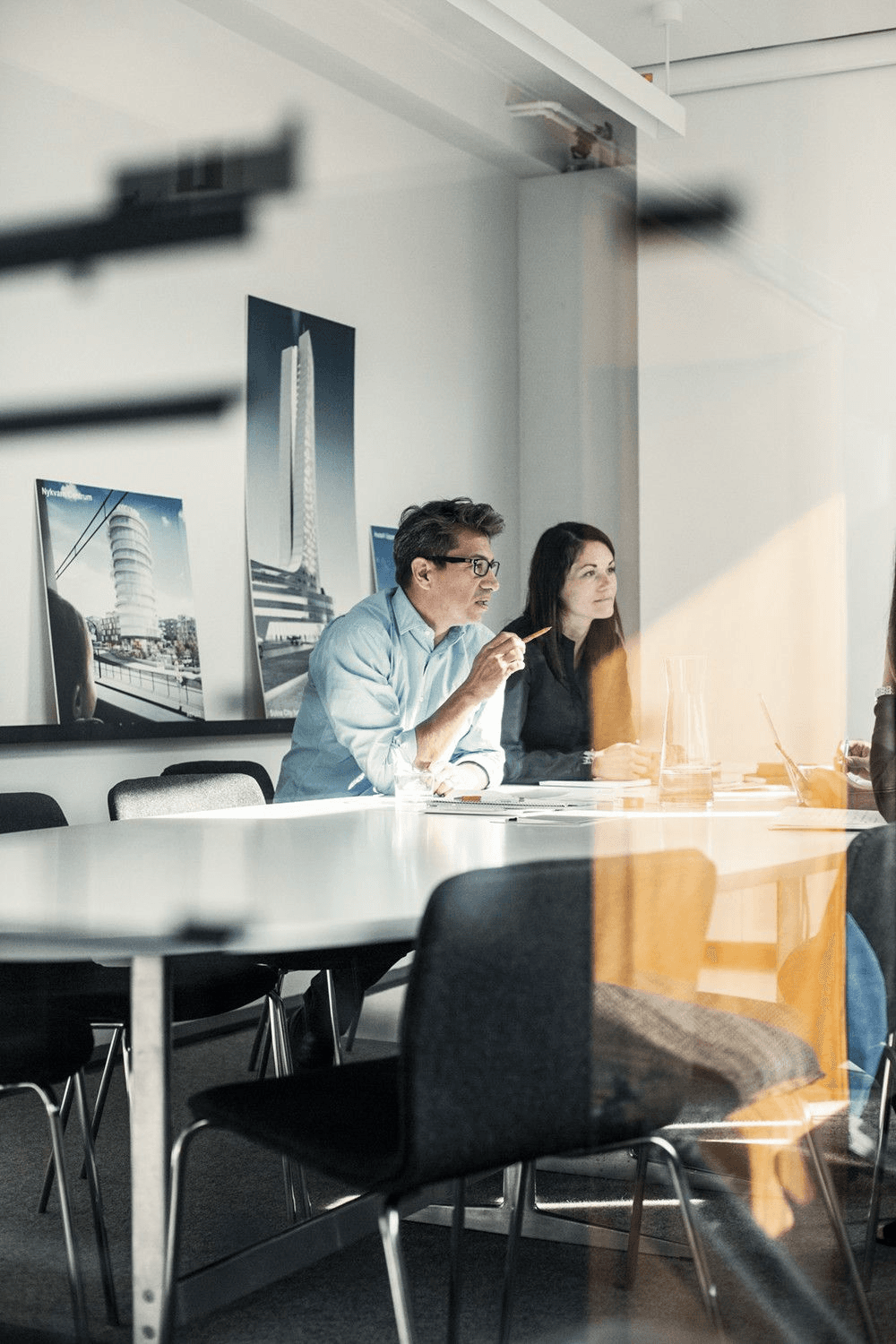 Consultants meeting in a glass-walled room