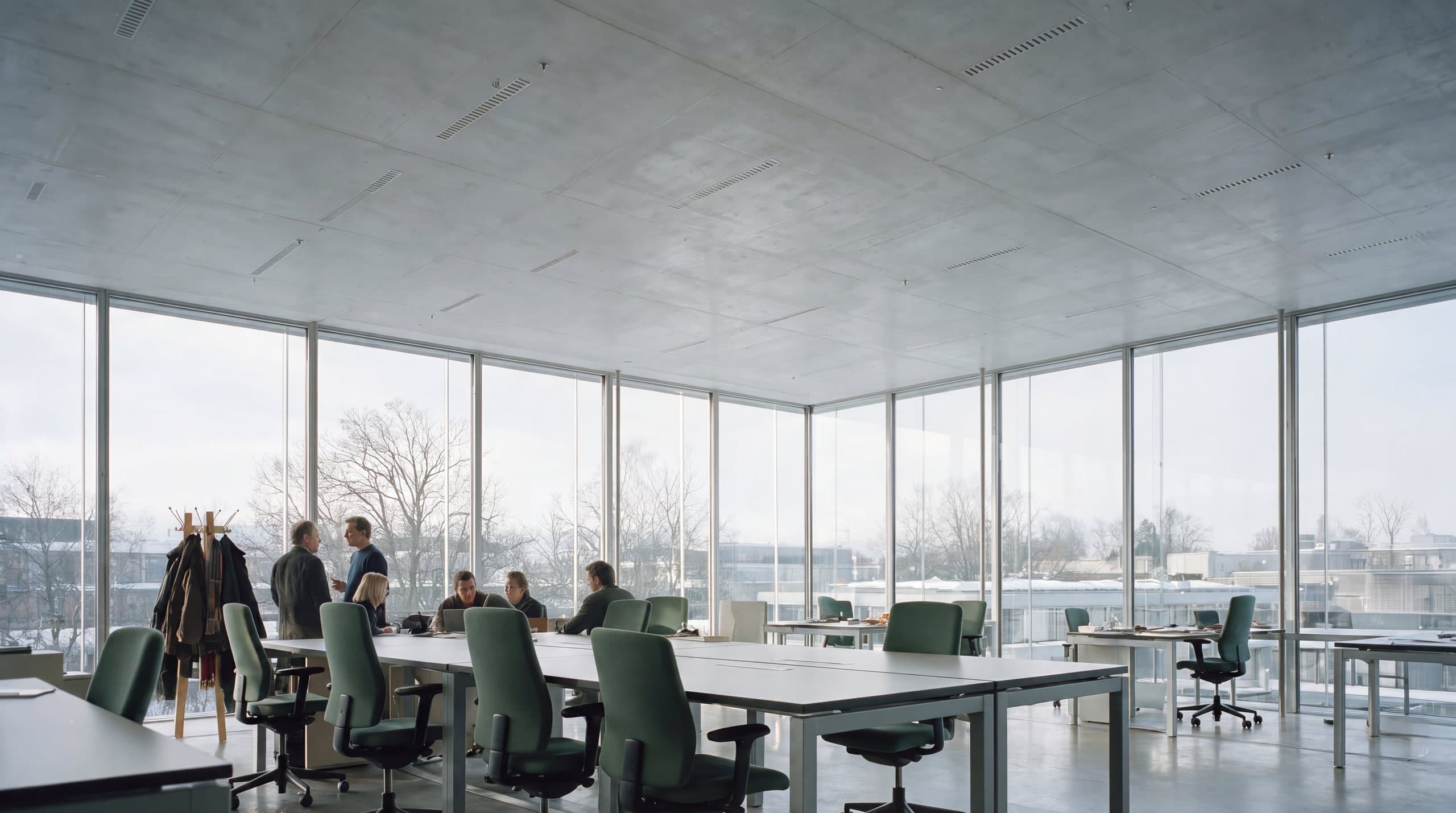 Bright glass-walled office with a team meeting at a long table